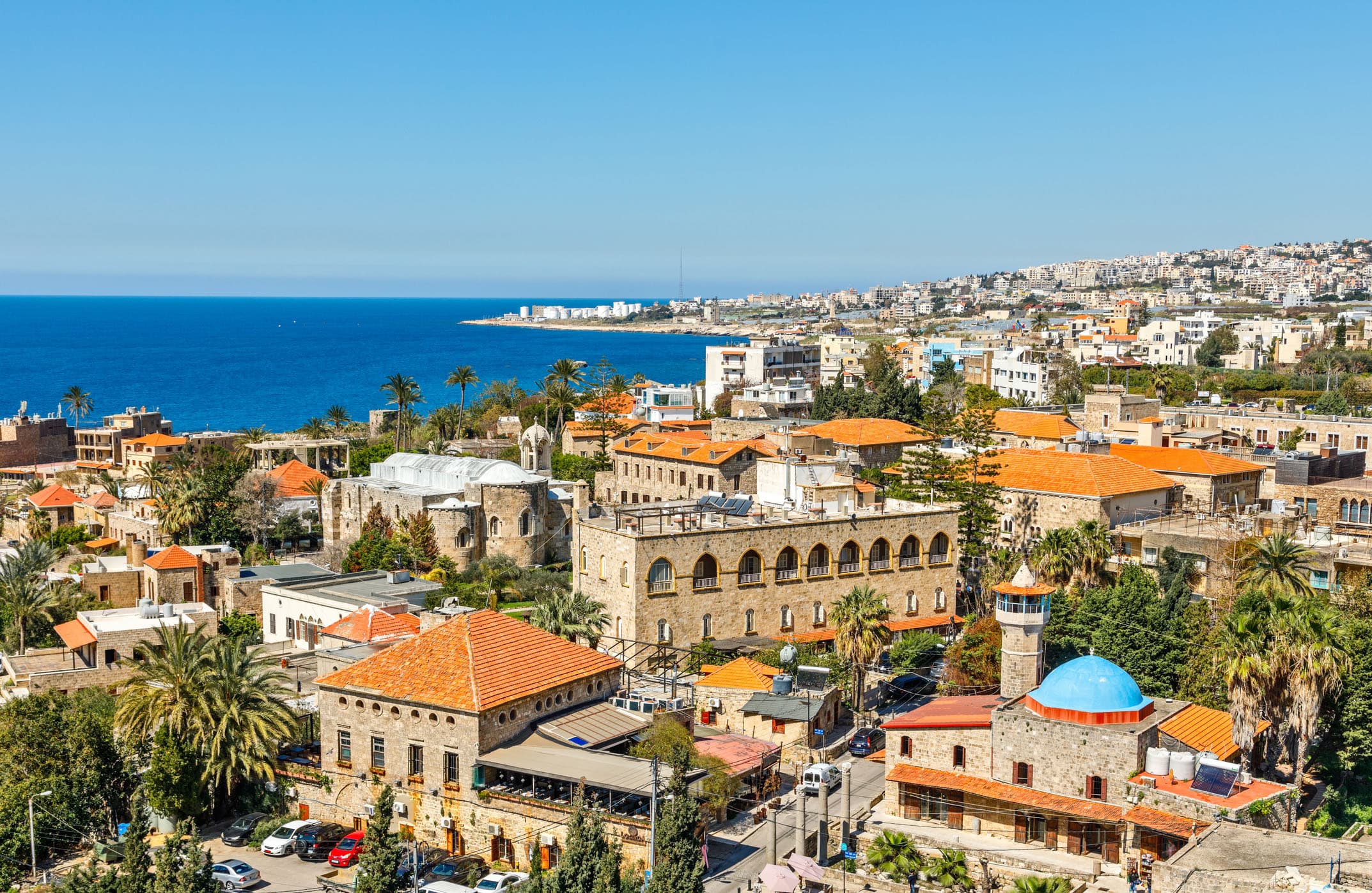 Aerial view of Lebanon's Mediterranean coastline meeting the Mount Lebanon range, with the historic port of Byblos visible in the foreground