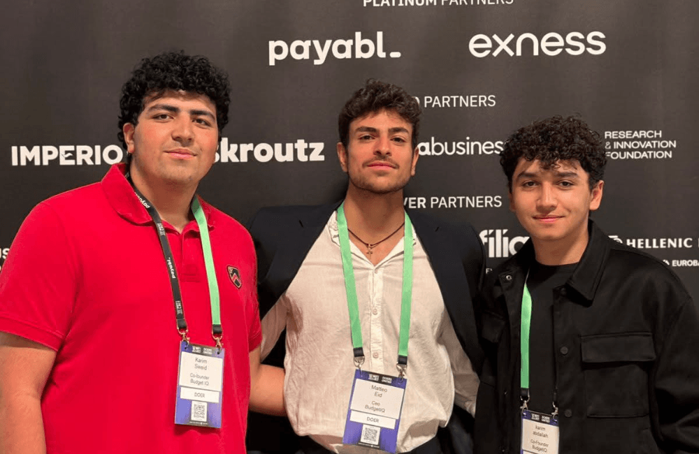 Two BudgetIQ founders with the app's gamified budgeting interface shown on a phone screen