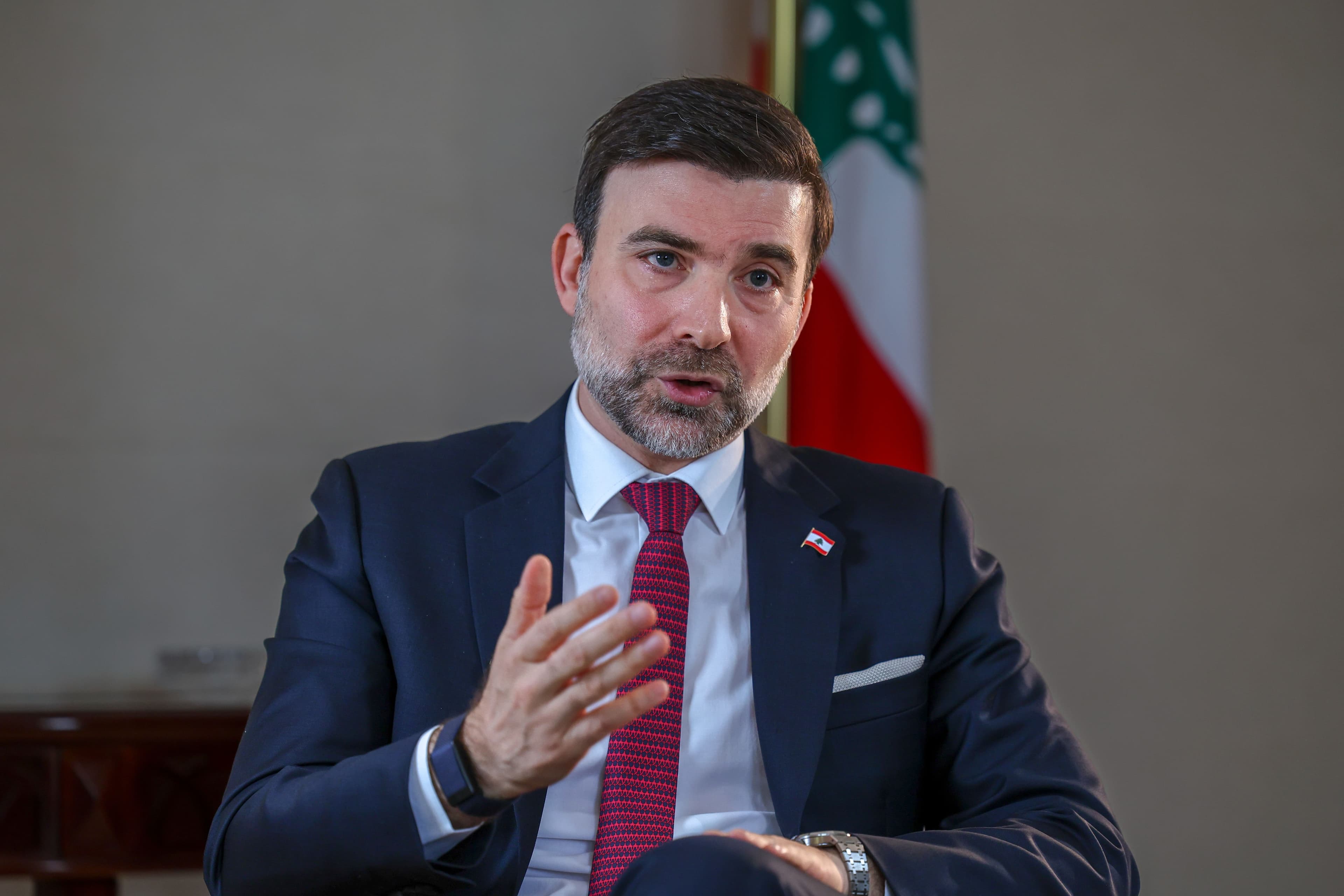 Tarek Mneimneh, Lebanon's ambassador to the UAE, speaking during an interview with a Lebanese flag behind him