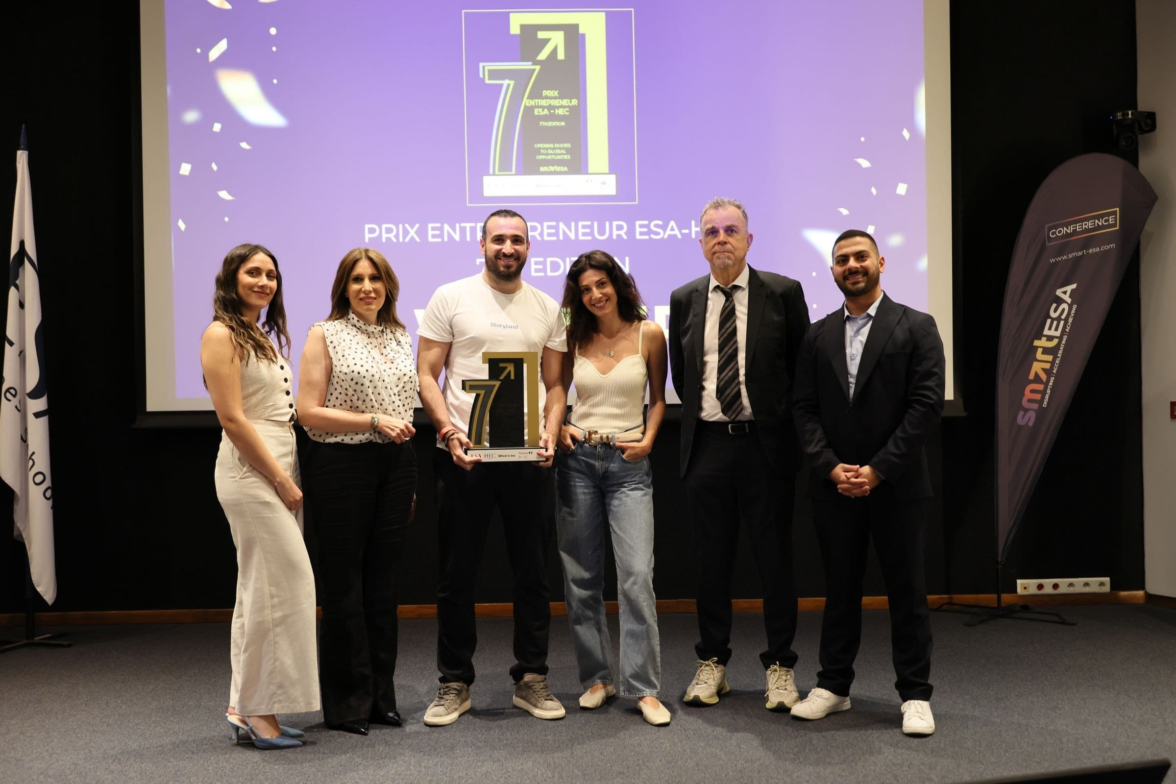 Storyland founder Malek Fatte on stage at ESA Business School in Beirut holding the ESA-HEC Entrepreneur Prize 2026 trophy
