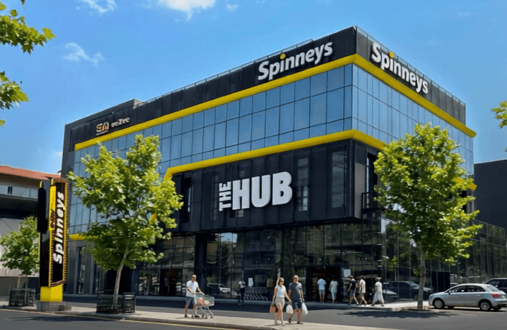 The new Spinneys branch in Amioun, a multi-floor store with a yellow The Hub facade, with shoppers arriving on opening day.