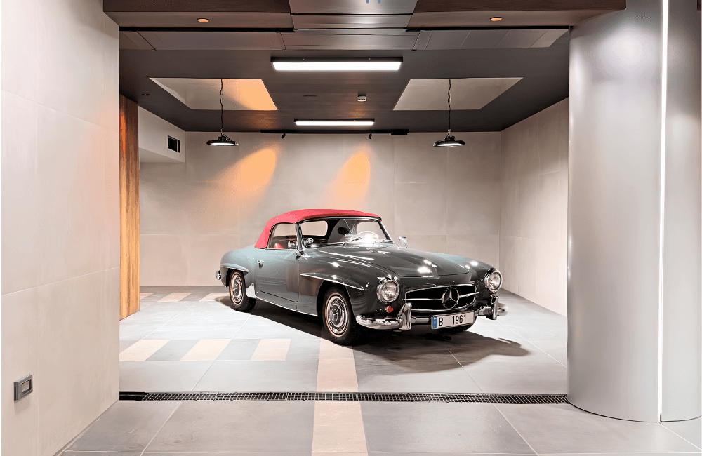 Restored vintage Mercedes-Benz 190 SL roadster displayed under spotlights in a minimalist Beirut garage