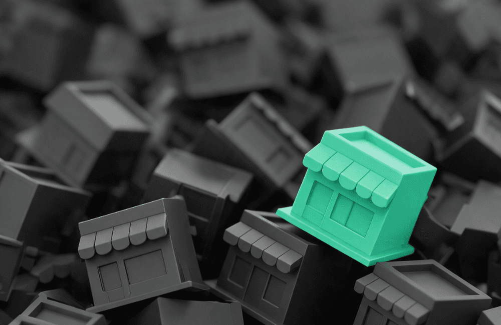 A green miniature storefront stands out on top of a pile of identical grey storefronts, showing a business that stands out from the crowd in search results.