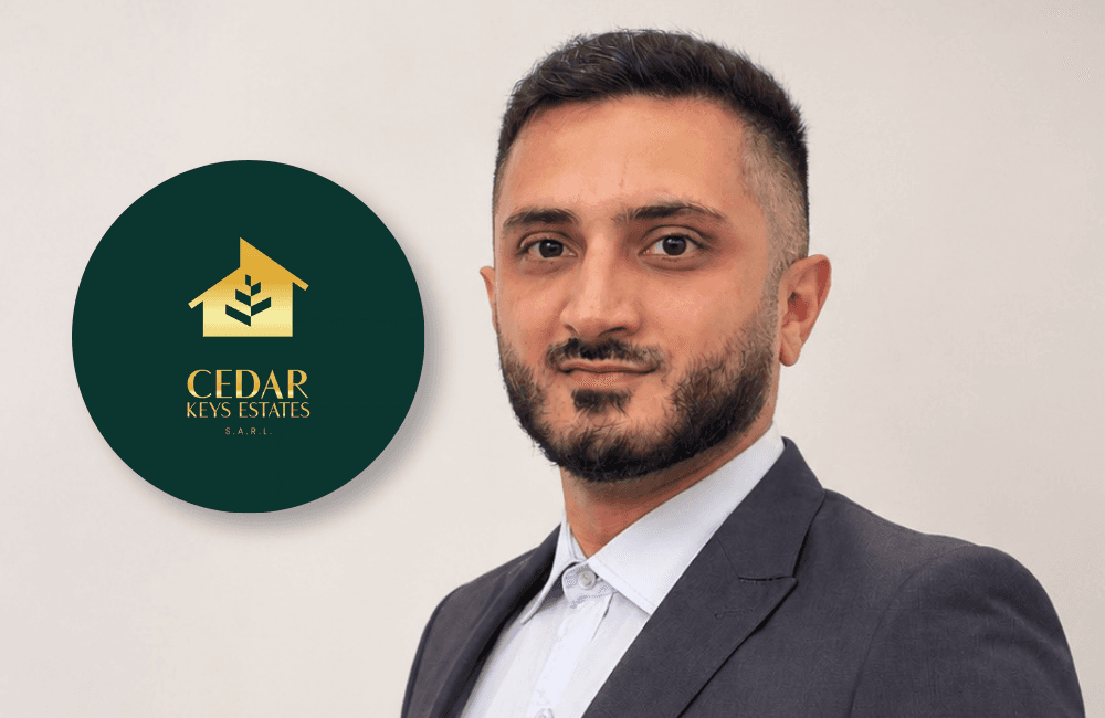 Mustapha Fouladkar, founder of Cedar Keys Estates, in a dark suit and light blue shirt beside the gold and dark green Cedar Keys Estates S.A.R.L. logo